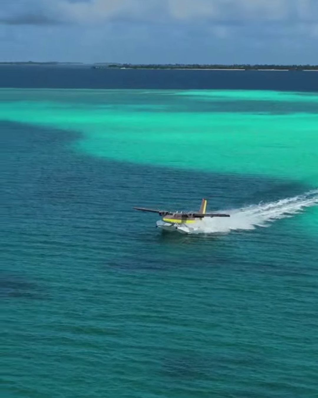 A seaplane taking off across a Maldives lagoon